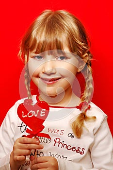 Little girl with heart shape lolly