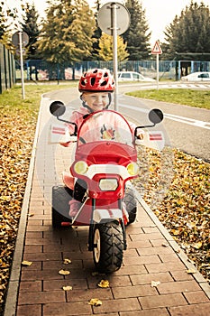 Little girl in helmet on the motorbike on the playground