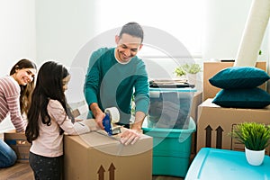 Little girl helping her parents to pack during moving day