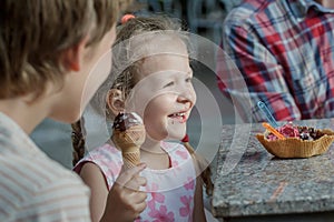 Little girl and her brother laughing during eating Italian ice cream