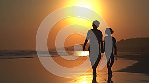 Little girl and her brother walking on beach