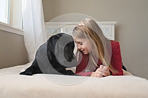 Little girl and her dog on the bed.