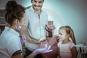 Little girl with her father at dentist office.