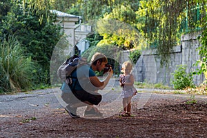 Little girl with her father among greenery photo