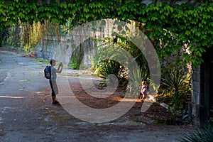 Little girl with her father among greenery photo