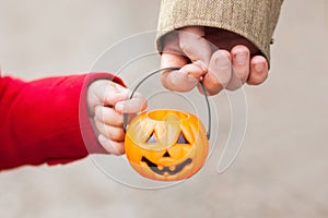 Little girl and her father, Halloween, parent and child trick or treating together. Toddler kid with jack-o-lantern.