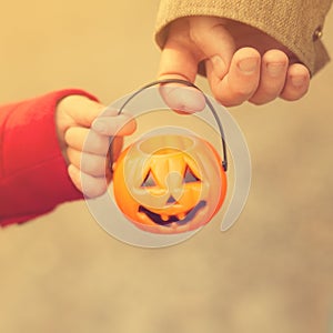 Little girl and her father, Halloween, parent and child trick or treating together. Toddler kid with jack-o-lantern.
