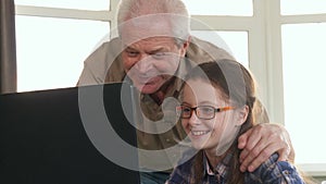 Little girl and her grandpa have video chat on laptop