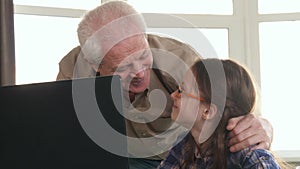 Little girl and her grandpa have video chat on laptop