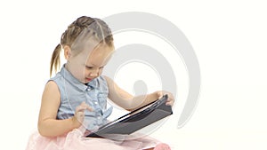 Little girl in her hands is holding aipad. White background