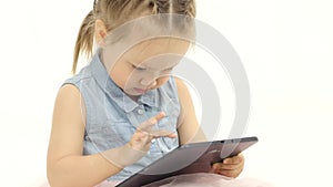 Little girl in her hands is holding aipad. White background