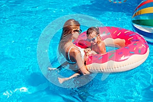 Little girl with her mom in swimming pool.