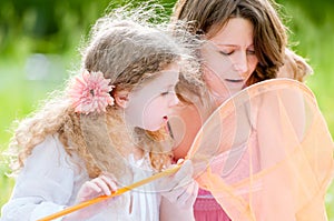 Little girl and her mother with butterfly net