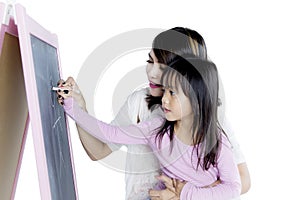 Little girl with her mother drawing with chalk