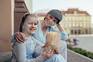 Little girl with her mother eating popcorn in city