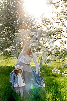 A little girl and her mother are walking in the meadow