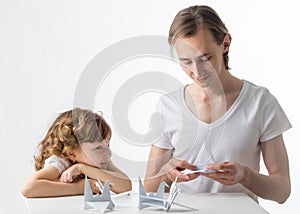 Little girl with her older brother does paper cranes