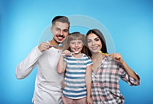 Little girl and her parents brushing teeth together