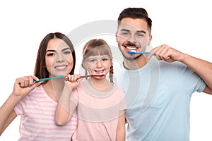 Little girl and her parents brushing teeth together