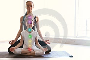 Little girl and her teacher practicing yoga