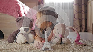 Little girl with her toys at children room dreaming about travel to Paris. Child dream, vacation and travel concept.