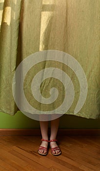 Little girl hid behind the curtain