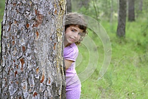 Little girl hide park tree trunk green outdoor