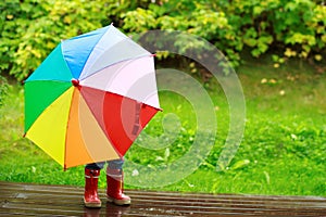 Little girl hiding behind umbrella