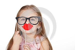 Little girl in hiding her face after fake glasses and paper lips