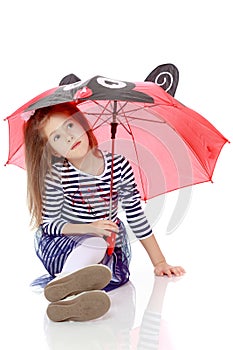 Little girl hiding under an umbrella.