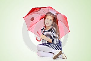 Little girl hiding under an umbrella.