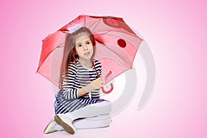 Little girl hiding under an umbrella.