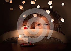 Little girl hiding in wait of Father Christmas