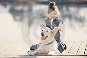 Little girl with his beloved dog at the lake