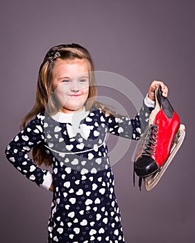 Little girl with hockey players skate in the hand