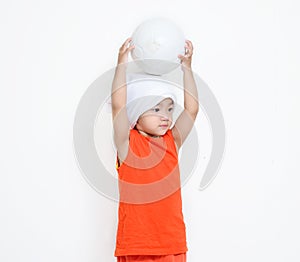 Little girl hold her ball on her head.