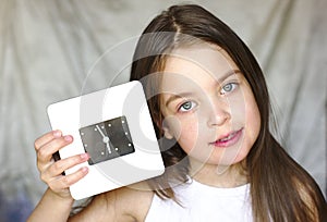 Little girl holding an alarm clock