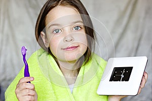 Little girl holding an alarm clock