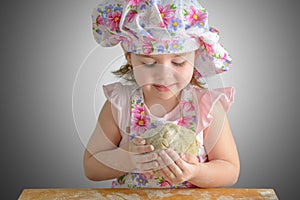 Little girl holding a ball of dough