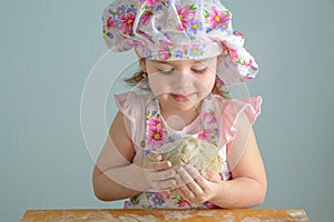 Little girl holding a ball of dough