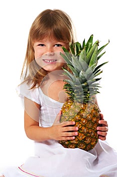 Little girl holding big pineapple