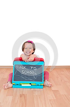 Little girl holding a blackboard with the text Back to school written on it, isolated