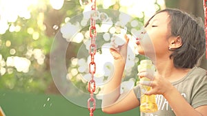 Little girl holding and blowing soap bubbles