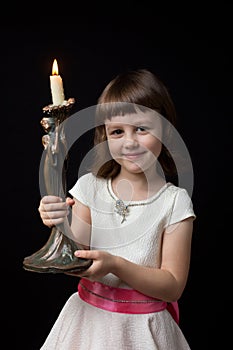 Little girl holding a candlestick