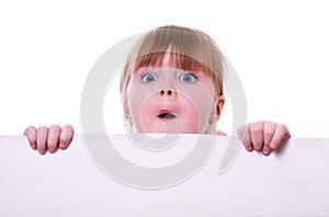 Little girl holding a cardboard looking surprised