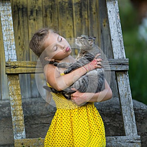 Little girl holding a cat in her arms.