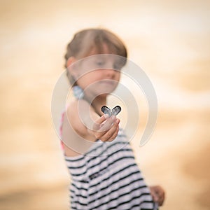 Little girl holding a conch shell