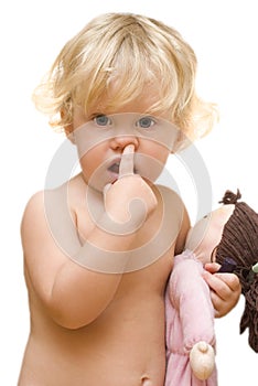 Little girl holding a doll and picks his nose