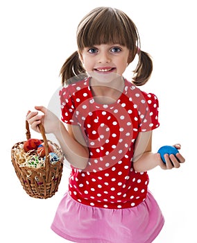 Little girl holding easter eggs in a basket