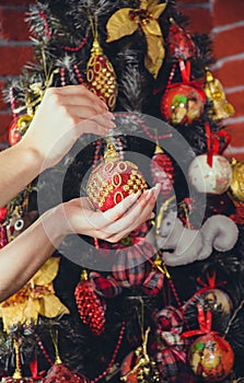 Little girl holding a fir-tree toy. Christmas and new year concept. Child`s hands holding beautiful christmas toy on the